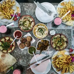 Obfity posiłek w Jordanii: hummus, falafel, frytki, sałatka i napoje. Ceny jedzenia w Jordanii są przystępne.