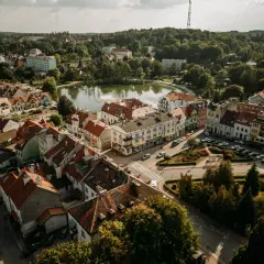 Widok z lotu ptaka na urokliwe Mrągowo. Jezioro, kolorowe kamienice i zielone drzewa tworzą malowniczy krajobraz. Odkryj mrągowo atrakcje!