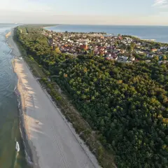 Plaża i las na Pomorzu, ukryte perełki, które warto odkryć. Widok z lotu ptaka na wybrzeże i urokliwe miasteczko.