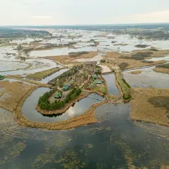 Skit w Odrynkach otoczony wodą i trzcinami, widok z lotu ptaka.