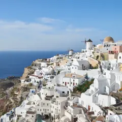 Malownicze białe domy Santorini, wiatraki i błękitne morze. Idealne miejsce na wycieczki z kos.