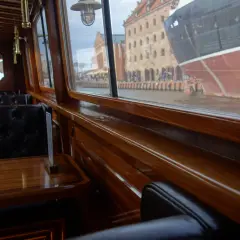 Eleganckie wnętrze statku w Gdańsku, z widokiem na zabytkowe kamienice i cumujący statek. Idealne miejsce na romantyczny wieczór, oferujące wyjątkowe gdańskie atrakcje dla dorosłych.