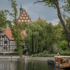 Bydgoszcz atrakcje: malowniczy widok na Brdę, zabytkową kamieniczkę i wieżę kościelną. Rejs statkiem po rzece to świetny pomysł na zwiedzanie.