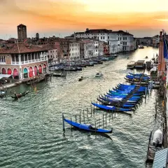 Wenecja co zobaczyć w 1 dzień: gondole czekają nad Canal Grande, a zachodzące słońce maluje niebo.
