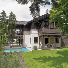 Elegancki świdermajer otwocki z basenem i tarasem, otoczony zielenią.