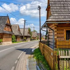 Drewniane domy w stylu zakopiańskim wzdłuż drogi. Wiele atrakcji w okolicy Chochołowa czeka na odkrycie.
