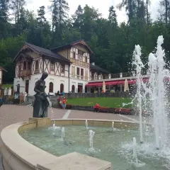 Fontanna i rzeźba w centrum, z pięknymi budynkami w tle. To jedne z wielu atrakcji Szczawnicy.