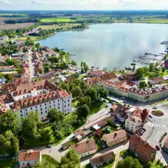 Idealne miejsce, gdzie na Mazury we dwoje: urokliwe miasteczko z zamkiem, jezioro z przystanią i zielone pola.