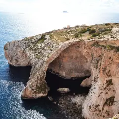 Malta na własną rękę: skaliste wybrzeże z jaskinią morską i turkusową wodą.