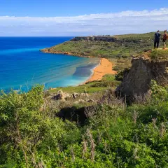 Malta w styczniu: słoneczna plaża, turkusowe morze i zielone wzgórza. Idealna temperatura na spacer.