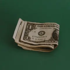 Kilka banknotów jednodolarowych leży na zielonym tle. Zastanawiasz się, jaki napiwek w restauracji zostawić?