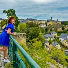 Kobieta w niebieskiej sukience podziwia panoramę Luksemburga. Warto zobaczyć to miasto pełne urokliwych uliczek i zabytków.