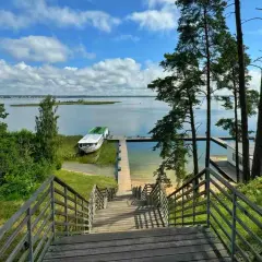 Idealne miejsce na mazury na weekend. Drewniane schody prowadzą do jeziora z łodzią i pomostem.