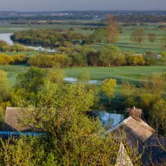 Podlasie samochodem: malownicze łąki, meandrująca rzeka i bocianie gniazdo na dachu. Idealne miejsce na spokojną podróż.