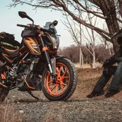 Pomarańczowy motocykl KTM z sakwami, gotowy na przygodę. Idealny sprzęt na pierwsze enduro.