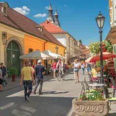 Tętniąca życiem ulica w Egerze, Węgry. Ludzie spacerują, jeżdżą na rowerze, siedzą w kawiarniach. Węgry atrakcje turystyczne.