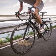 Rowerzysta w rękawiczkach i spodenkach ściga się po drodze. Czy rowerzysta może wyprzedzać z prawej strony? To zależy od przepisów.