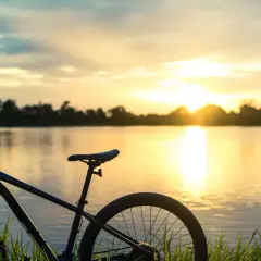Rower czeka na odkrywanie malowniczych tras rowerowych Mazur o zachodzie słońca nad jeziorem.