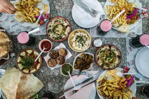Obfity posiłek w Jordanii: hummus, falafel, frytki, sałatka i napoje. Ceny jedzenia w Jordanii są przystępne.