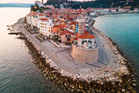 Piran plaża: malownicze miasteczko na półwyspie, z kolorowymi domami, kamienną promenadą i wieżą kościelną górującą nad Adriatykiem.