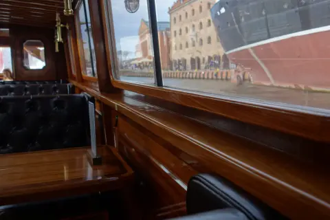 Eleganckie wnętrze statku w Gdańsku, z widokiem na zabytkowe kamienice i cumujący statek. Idealne miejsce na romantyczny wieczór, oferujące wyjątkowe gdańskie atrakcje dla dorosłych.