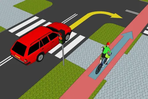 Rowerzysta jedzie po ścieżce rowerowej, zgodnie z przepisami. Samochód czeka na zielone światło.