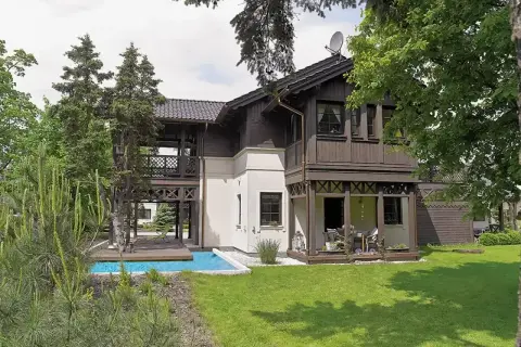Elegancki świdermajer otwocki z basenem i tarasem, otoczony zielenią.