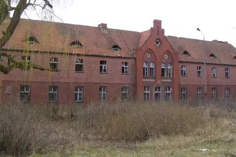 Opuszczony budynek z cegły, zniszczony dach i wybite okna. Miejsce to mogłoby być jednym z nawiedzonych miejsc w Polsce, pełnym mrocznych historii.