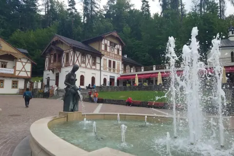 Fontanna i rzeźba w centrum, z pięknymi budynkami w tle. To jedne z wielu atrakcji Szczawnicy.