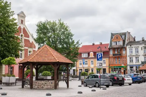 Rynek w Starogardzie Gdańskim, stolicy Kociewia, z drewnianą studnią i kolorowymi kamienicami.