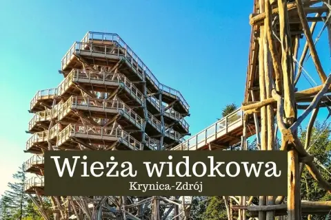 Drewniana wieża widokowa w Krynicy-Zdroju wznosi się ku błękitnemu niebu, oferując wspaniałe widoki na okolicę.