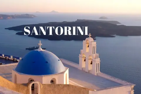 Santorini co zobaczyć: błękitna kopuła kościoła i dzwonnica na tle kalderze. Widok zapiera dech w piersiach!