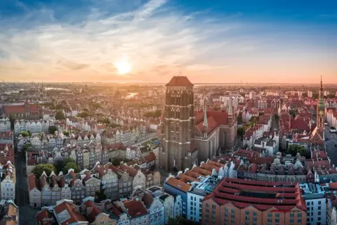 Zachód słońca nad Gdańskiem, ukazujący Bazylikę Mariacką i inne trójmiasto atrakcje.