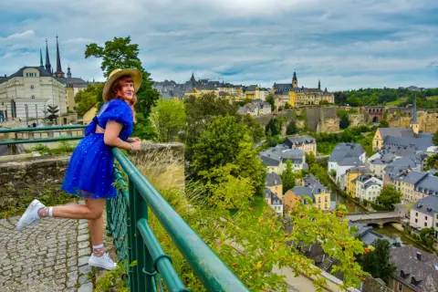 Kobieta w niebieskiej sukience podziwia panoramę Luksemburga. Warto zobaczyć to miasto pełne urokliwych uliczek i zabytków.