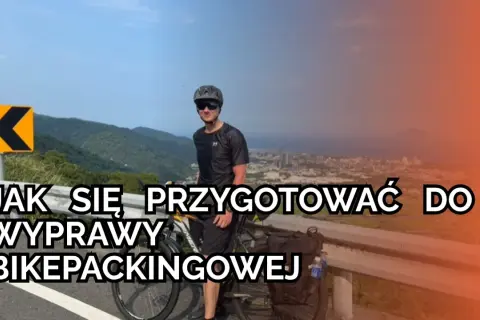Mężczyzna z rowerem na górskiej drodze, przygotowuje się do wyprawy bikepackingowej. Informacje o rowerze i trasie.