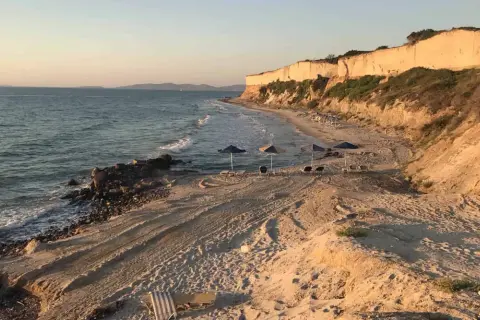 Plaża z klifem w tle, morze i leżaki. Czy warto tu przyjechać? Zdecydowanie tak!