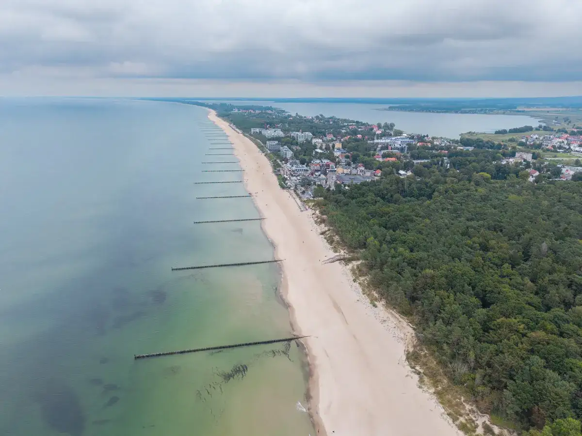 Mielno atrakcje: szeroka plaża, morze, las i zabudowania kurortu widziane z lotu ptaka.