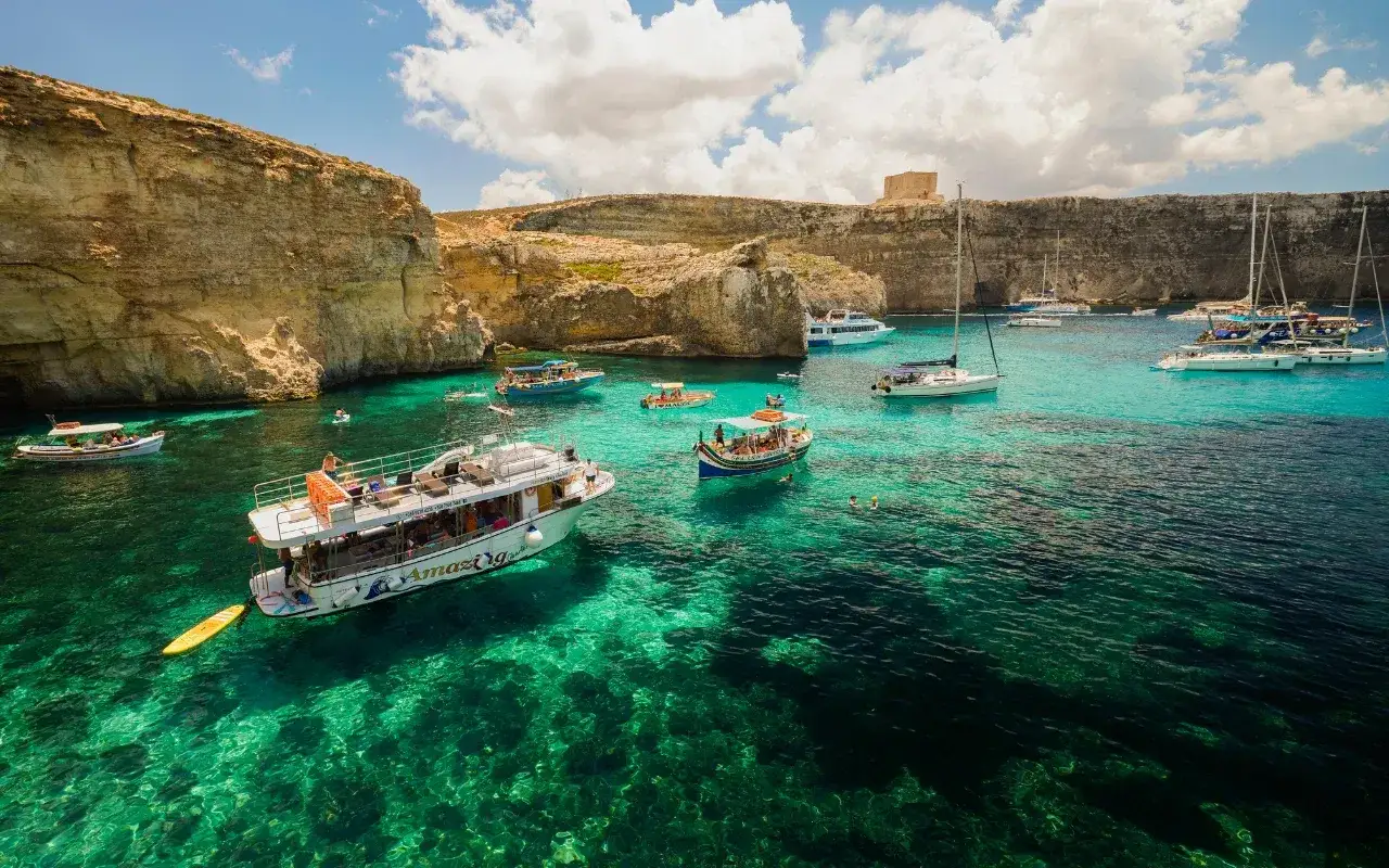 Malta w listopadzie: turkusowa woda, klify i łodzie w Zatoce Błękitnej. Nawet jesienią można tu pływać i podziwiać widoki.
