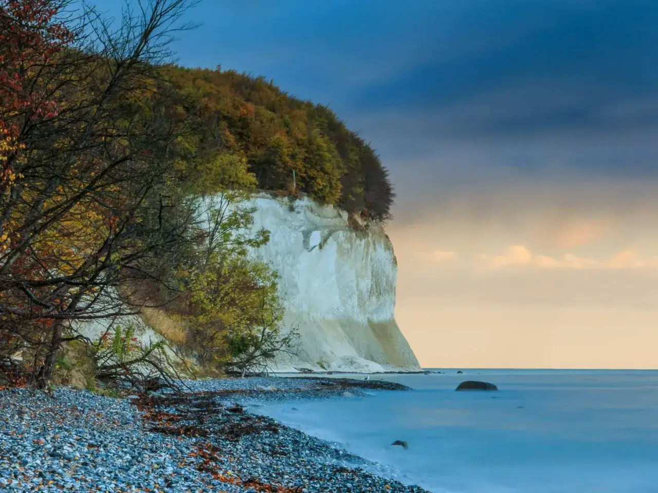 Piękny klif porośnięty jesiennym lasem, plaża z kamieni i spokojne morze. Czy Polska ma wyspę? Nie, ale ma takie krajobrazy!
