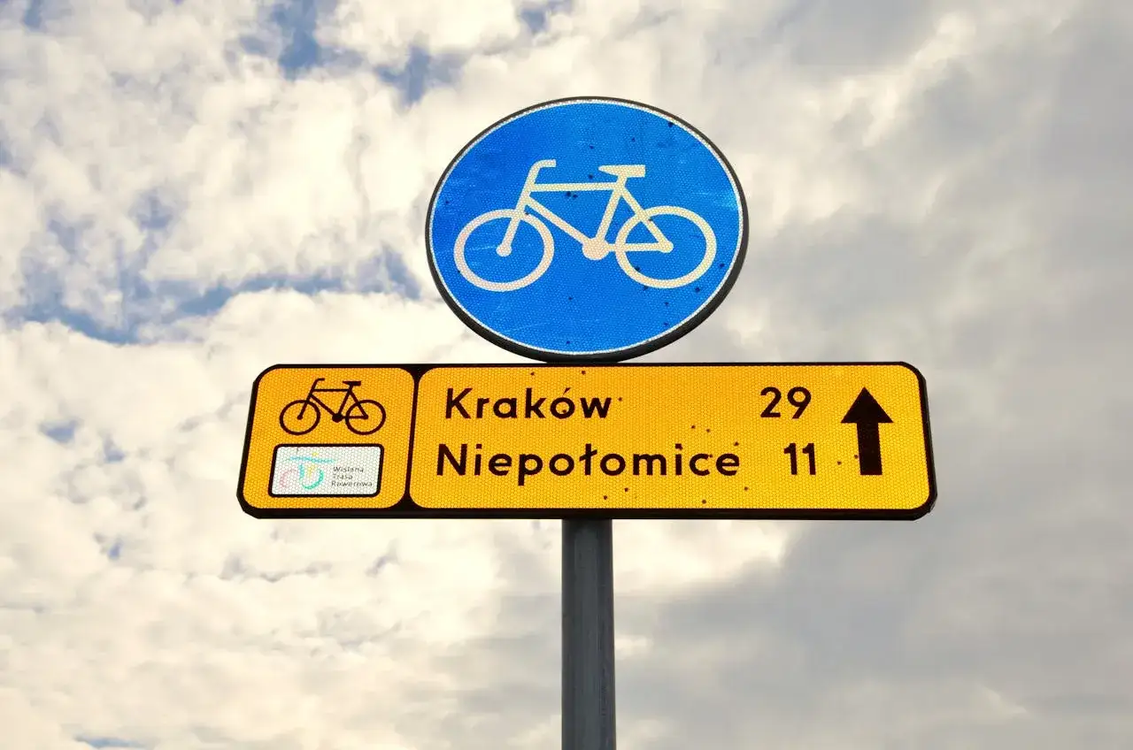 Znak drogowy informuje, że kiedy rowerzysta ma pierwszeństwo, kieruje się na Kraków (29 km) i Niepołomice (11 km).