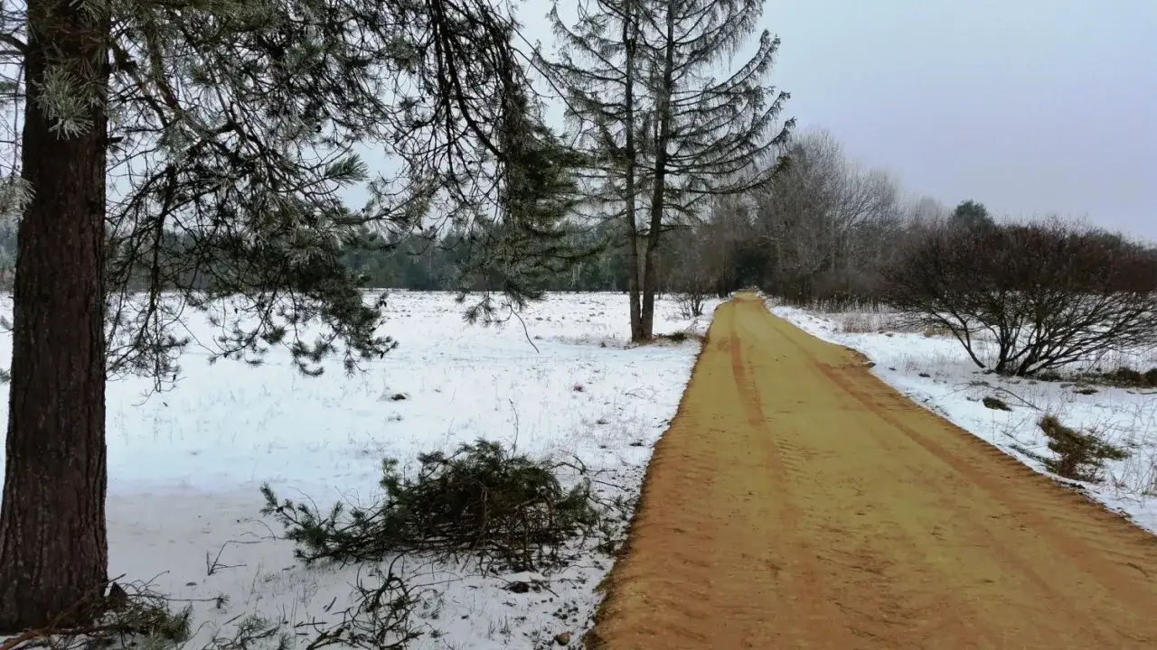 Zimowa trasa rowerowa Czarny Dunajec wita śniegiem i piaszczystą drogą.