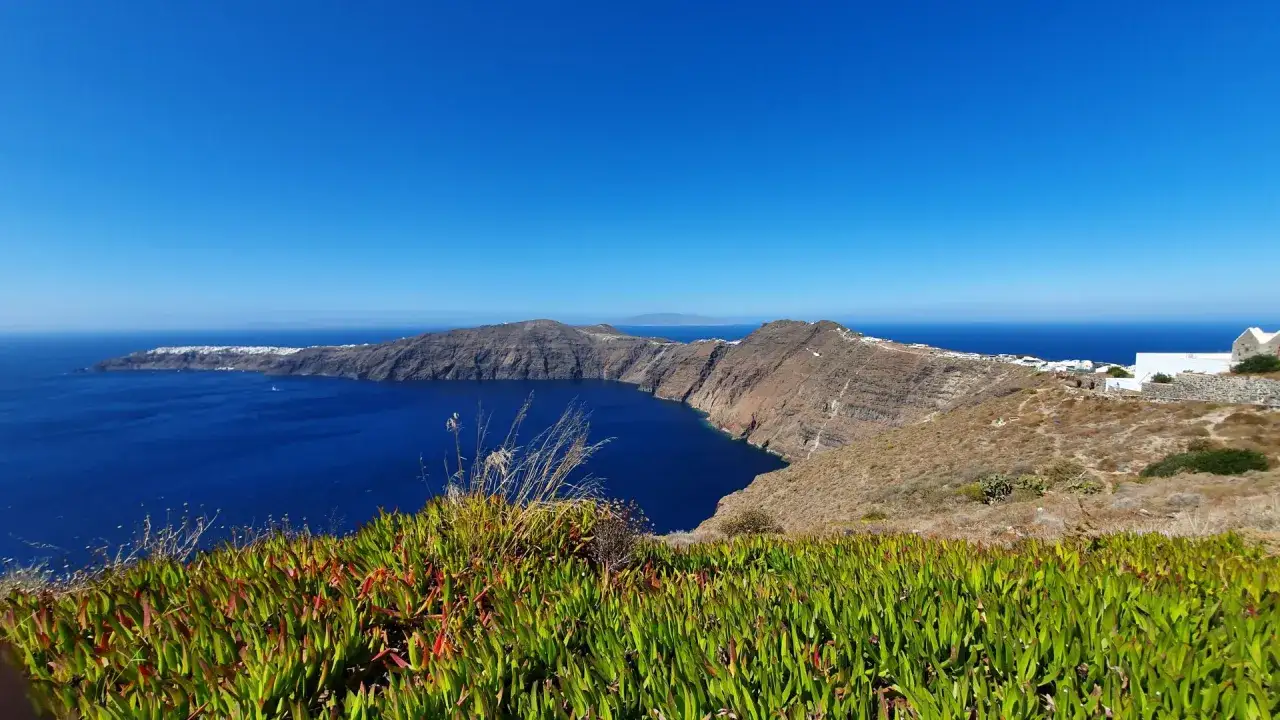 Widok na kalderę Santorini, idealny punkt startowy do planowania zwiedzania. Białe domki na klifie, błękitne morze.